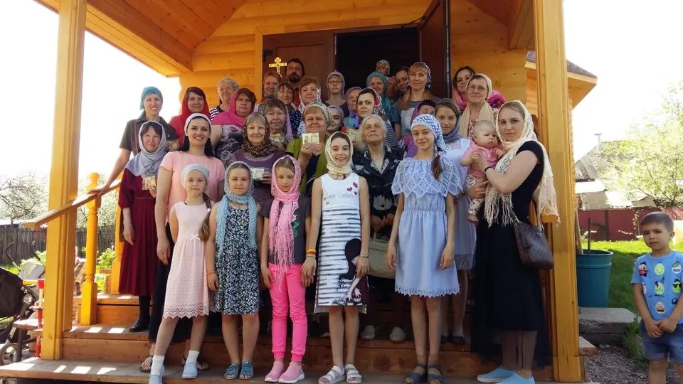 Группа женщин и девочек в храме позируют для общей фотографии в честь праздника